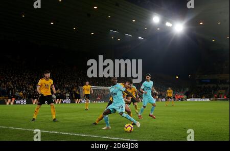 Christian Atsu (Mitte) von Newcastle United unter dem Druck von Wolverhampton Wanderers' Leander Dendoncker (hinten) Stockfoto