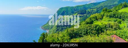 Aussichtspunkt Ponta do Sossego, Sao Miguel Island, Azoren, Portugal. Blick auf Blumen auf einem Berg und das Meer in Miradouro da Ponta do Sossego Nordeste Stockfoto