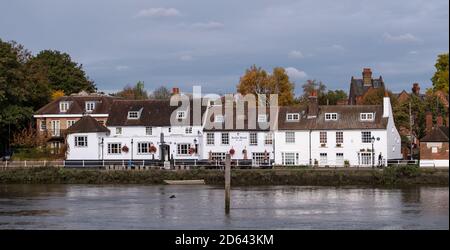 The Bull's Head, historisches Pub am Strand on the Green, Kew, West London. Fotografiert von der anderen Seite der Themse. Kew Eisenbahnbrücke in der Vorgruppe Stockfoto