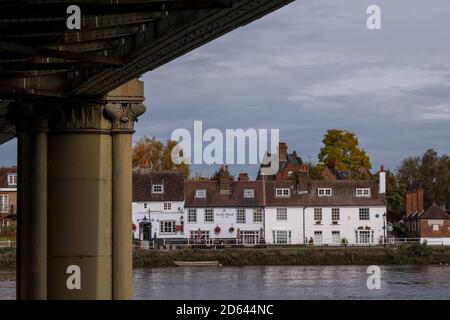 The Bull's Head, historisches Pub am Strand on the Green, Kew, West London. Fotografiert von der anderen Seite der Themse. Kew Railway Bridge im Vordergrund Stockfoto