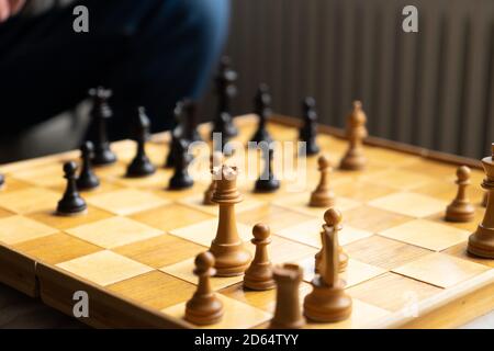 Ein Schachspiel, das gespielt wird, Blick auf das Brett mit einem Teil eines nicht erkennbaren Mannes Stockfoto