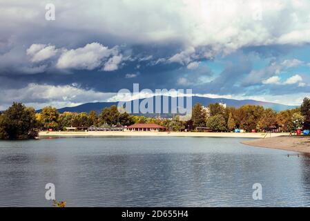 See und Berg gegen blauen Himmel mit Wolken. Stürmisches Wetter. Jarun See, Zagreb, Kroatien. Stockfoto