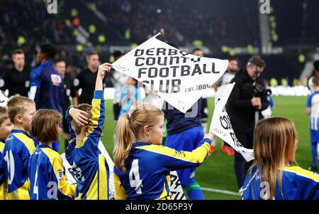 Maskottchen halten die Fahnen des Derby County Football Club fest, während die Spieler vor dem Spiel auf das Spielfeld gehen Stockfoto