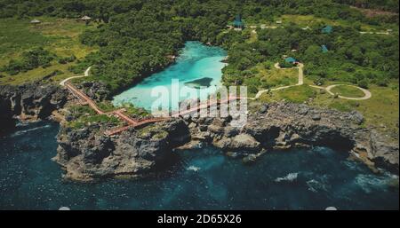 Cliff Sea Küste mit grüner Landschaft mit limpid See auf der Spitze in Luftaufnahme. Landschaftlich reizvolle Meereslandschaft bewundern Sie die tropische Vegetation in der Lagune von Weekuri, Sumba Island, Indonesien. Drohnenaufnahme im Kino Stockfoto