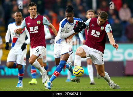 Wilfried Zaha (Mitte) von Crystal Palace und James Tarkowski von Burnley kämpfen um den Ball Stockfoto