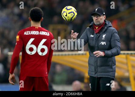 Liverpools Manager Jurgen Klopp (rechts) wirft den Ball an Liverpools Trent Alexander-Arnold (links) Stockfoto