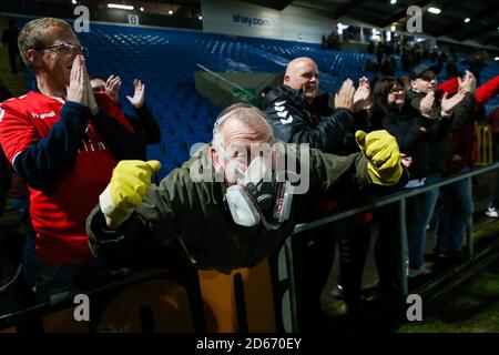 Ein Ebbsfleet Fan, der eine Schutzmaske trägt, feiert den Sieg gegen den FC Halifax Town während des Premier-League-Spiels der Vanarama Conference im Shay Stockfoto