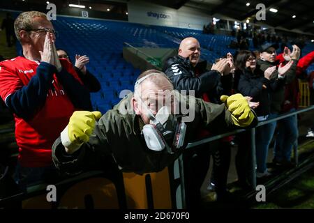 Ein Ebbsfleet Fan, der eine Schutzmaske trägt, feiert den Sieg gegen den FC Halifax Town während des Premier-League-Spiels der Vanarama Conference im Shay Stockfoto