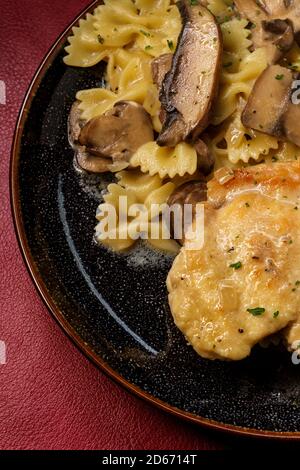 Italienische Küche Huhn marsala mit Pilzen in einem cremigen Wein Und Whisky-Sauce über Farfalle Pasta Stockfoto