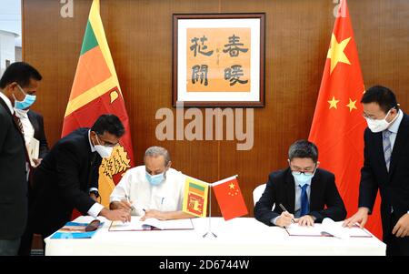 Colombo, Sri Lanka. Oktober 2020. HU Wei (2. R), Geschäftsträger der chinesischen Botschaft in Sri Lanka, und Vasudeva Nanayakkara (3. R), srilankischer Minister für Wasserversorgung, unterzeichnen am 14. Oktober 2020 in Colombo, der Hauptstadt Sri Lankas, ein Zusatzabkommen. Sri Lanka und China unterzeichneten am Mittwoch ein ergänzendes Abkommen über ein Memorandum of Understanding über die Zusammenarbeit in der Wasserforschung und -Technologie, das darauf abzielt, mehrere Gebiete des Inselstaates mit sauberem Trinkwasser zu versorgen, hieß es in einer Erklärung der chinesischen Botschaft in Sri Lanka. Quelle: Tang Lu/Xinhua/Alamy Live News Stockfoto