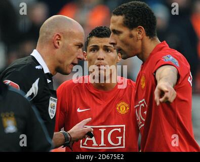 Manchester United Cristiano Ronaldo (Mitte) und Rio Ferdinand (rechts) streiten mit Schiedsrichter Howard Webb, nachdem Ronald die rote Karte gezeigt wurde. Stockfoto