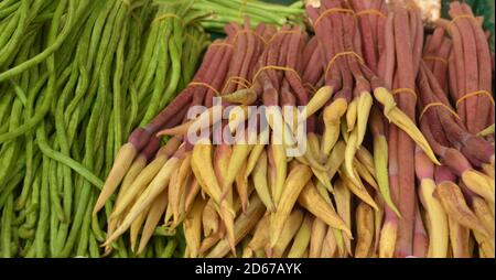 Braune Taroblume und grüne lange Bohne auf dem Stall Zu verkaufen auf dem Markt in Kunming von China Stockfoto