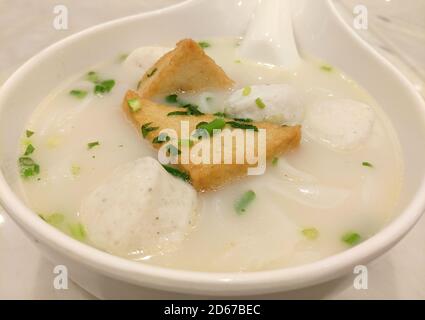 Gebratener Bohnenkerz und Fischball in der weißen Suppe In der Schüssel zum Essen Stockfoto