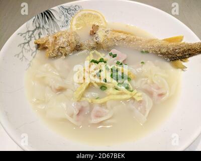 Gebratener Fisch und Knödel in der weißen Suppe Schüssel zum Essen Stockfoto