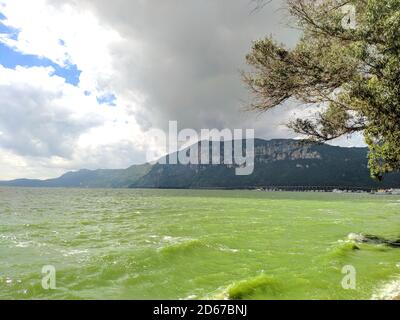 See mit grünem Wasser unter bewölktem Tag, während Sonnenlicht ist So hell Stockfoto