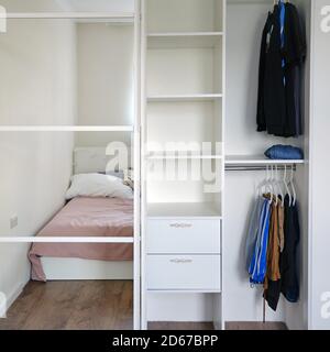 Kleiderschrank mit Spiegeltüren und Kleidung im Schlafzimmer Stockfoto