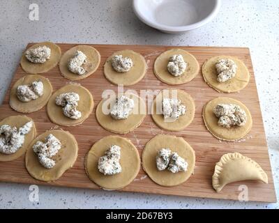 Herstellung von Pierogis mit Ricotta, Parmesan-Käse und Petersilie Füllung auf einem Holzbrett Stockfoto