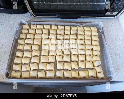 Ricotta gnocci gleichmäßig schneiden, bevor sie in einen Ofen gestellt werden Stockfoto