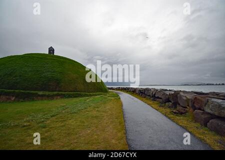 Thufa (Þúfa) von Ólöf Nordal ist eine Kunstinstallation am Eingang zum Hafen von Reykjavik, Island. Ein großer grasbewachsener Hügel mit einer Holzhütte auf der Spitze. Stockfoto