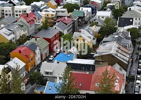 Ein Blick von der Spitze des Hallgrimskirkja Kirchturms. In der isländischen Stadt Reykjavik sind Reihen von bunten Häusern und geparkten Autos zu sehen. Stockfoto