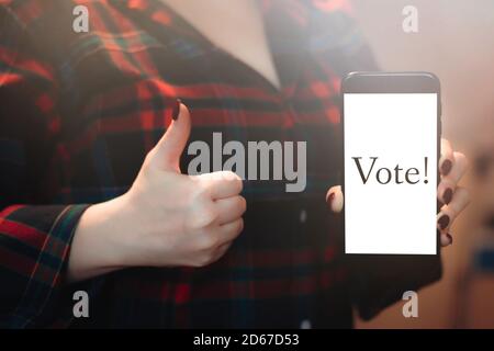 Frau stimmt online mit dem Telefon. Abstimmung und Wahlen Konzept. Stockfoto