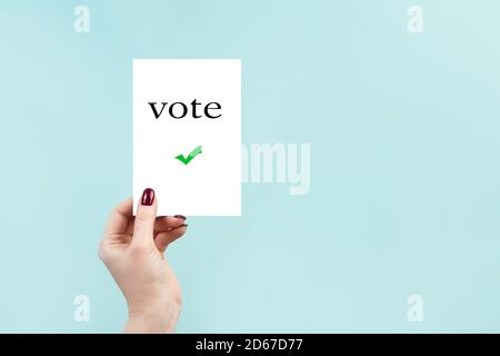 Konzept der Briefwahl, US-Wahlen. Eine Frau hält ein Schild auf blauem Hintergrund. Stockfoto