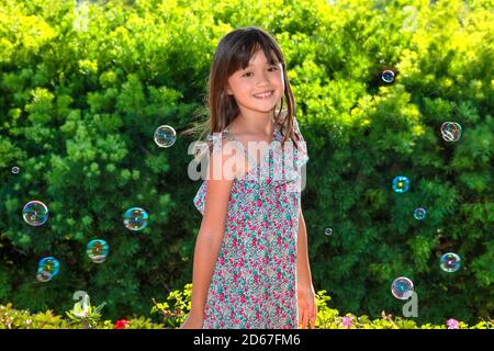 Acht Jahre altes Mädchen, umgeben von Seifenblasen Stockfoto