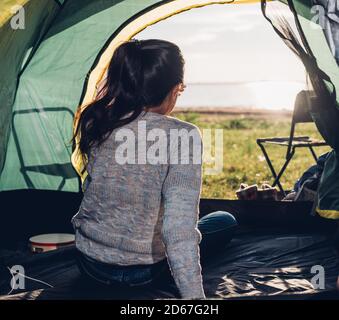Zurück eine Frau Innenansicht Camping Zelt im Sommer bei Naturwald Stockfoto