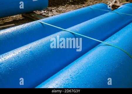 3 blaue Rohre mit Tauwasser-Tröpfchen. Stockfoto