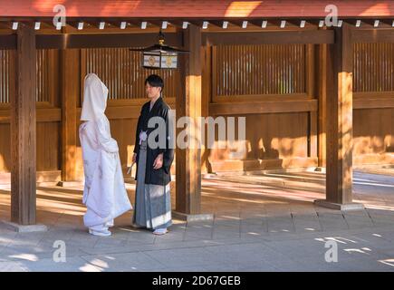 tokio, japan - oktober 10 2020: Traditionelle japanische shinto-Hochzeit eines Paares in schwarzem Haori-Kimono und weißem Shiromuku unter einer Laterne aus t Stockfoto