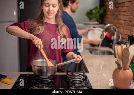 Paar bereitet Mahlzeiten zu und wäscht das Geschirr Stockfoto