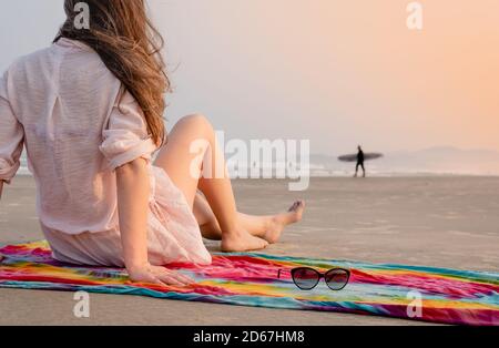 Frau, die den Surfermann am Strand ansieht Stockfoto