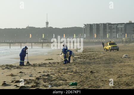 Sanitäter Reinigung Plastikverschmutzung am Strand, Durban, KwaZulu-Natal, Südafrika, Abfallwirtschaft, Menschen arbeiten, Küsten aufräumen Stockfoto