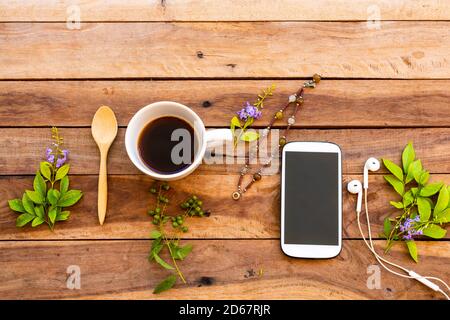 Handy, heiße Kaffee Zitrone und Blumen Frangipani Anordnung flach Lay Stil auf Hintergrund Holz Stockfoto