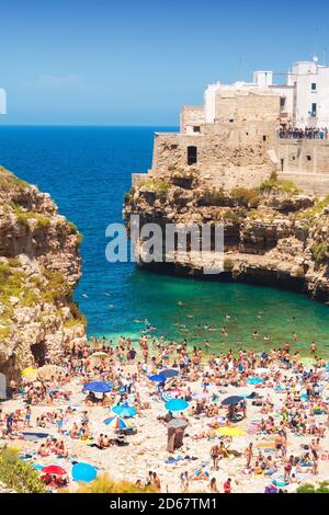 Cala Porto, auch bekannt als Lama Monachile Strand in Polignano a Mare, Apulien, Italien - 06/02/2018 - Massen von Touristen genießen den Strand Stockfoto