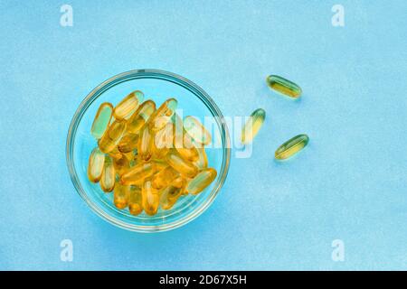 Fischöl Kapseln auf blauem Hintergrund - Omega 3 Vitamine und Gesundheitskonzept Stockfoto