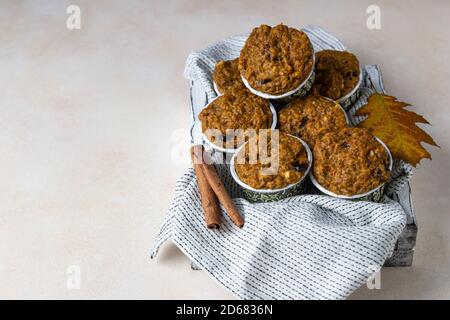 Gesunde vegane hausgemachte Karotten- oder Kürbismuffins mit Rosinen und Nüssen, heller Hintergrund. Stockfoto