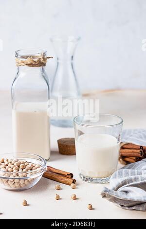 Kichererbsen vegetarische Milch in einer Flasche und Glas und rohe Kichererbsen auf hellem Hintergrund. Laktosefreie nicht-Milchprodukte. Gesundes veganes Lebensmittelkonzept. Stockfoto