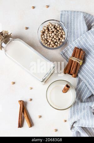 Kichererbsen vegetarische Milch in einer Flasche und Glas und rohe Kichererbsen auf hellem Hintergrund. Laktosefreie nicht-Milchprodukte. Gesundes veganes Lebensmittelkonzept. Oben Stockfoto