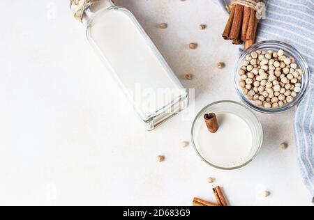 Kichererbsen vegetarische Milch in einer Flasche und Glas und rohe Kichererbsen auf hellem Hintergrund. Laktosefreie nicht-Milchprodukte. Gesundes veganes Lebensmittelkonzept. Oben Stockfoto