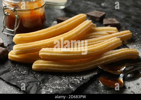 Konzept des Mittagessens mit Churros und Schokolade auf dunklem Tisch Stockfoto