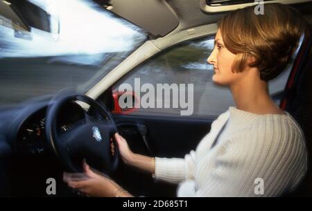 Junge Frau fährt einen Vauxhall Corsa Stockfoto