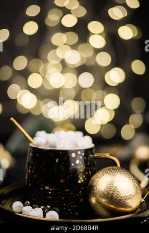 Hausgemachte dunkle heiße Schokolade Kakao mit Marshmallows auf einem schwarzen Weihnachten Hintergrund mit Golden Bokeh Stockfoto