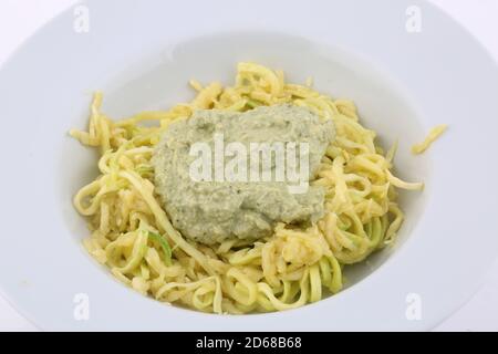 Zucchini-Spaguetti mit grünem Pesto als leckeres veganes gesundes Essen Stockfoto