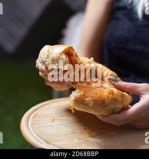 Kuchen mit Gemüse in den Händen einer Frau auf einem Tablett. Gemütliche authentische Atmosphäre. Stockfoto