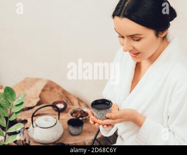 Porträt einer gesunden 35-jährigen Frau im Bademantel beim Tee trinken Und genießen Sie den Spa-Tag Stockfoto