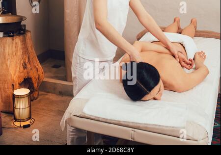 Entspannende Rücken- und Körpermassage im Spa. Frau mit gemischter Rasse genießt Massage im Spa Stockfoto
