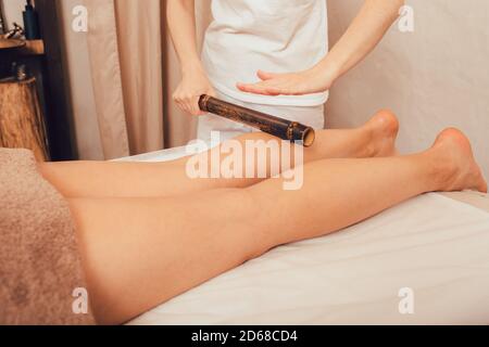 Frau mit Anti-Stress-Massage mit Bambusstäbchen. Spa Salon Verjüngende Körpermassage Stockfoto