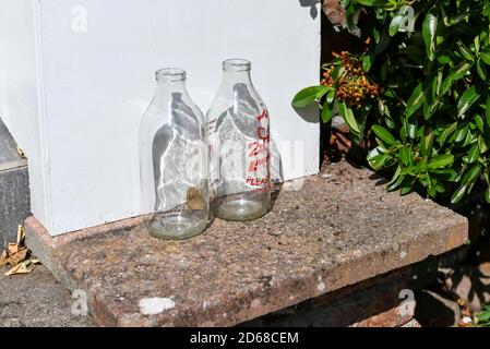 Nahaufnahme von sauberem Glas leere Milchflaschen Flasche vor einem Haus vor der Haustür England Großbritannien GB Großbritannien Stockfoto