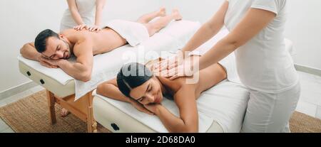 Wunderschönes Paar während der Rückenmassage, gemeinsamer Tag im Spa. Mann und Frau genießen eine Massage Stockfoto